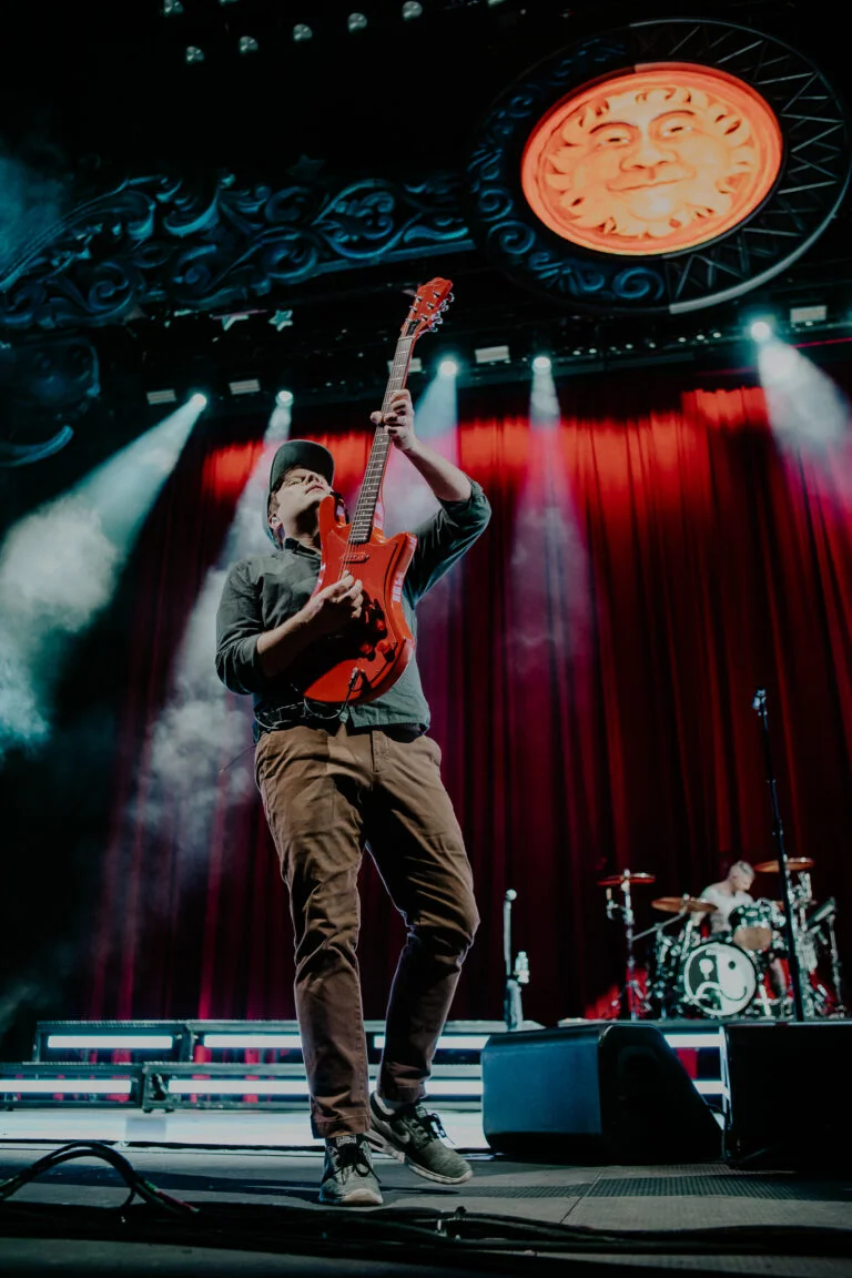 Patrick raising his guitar in the air