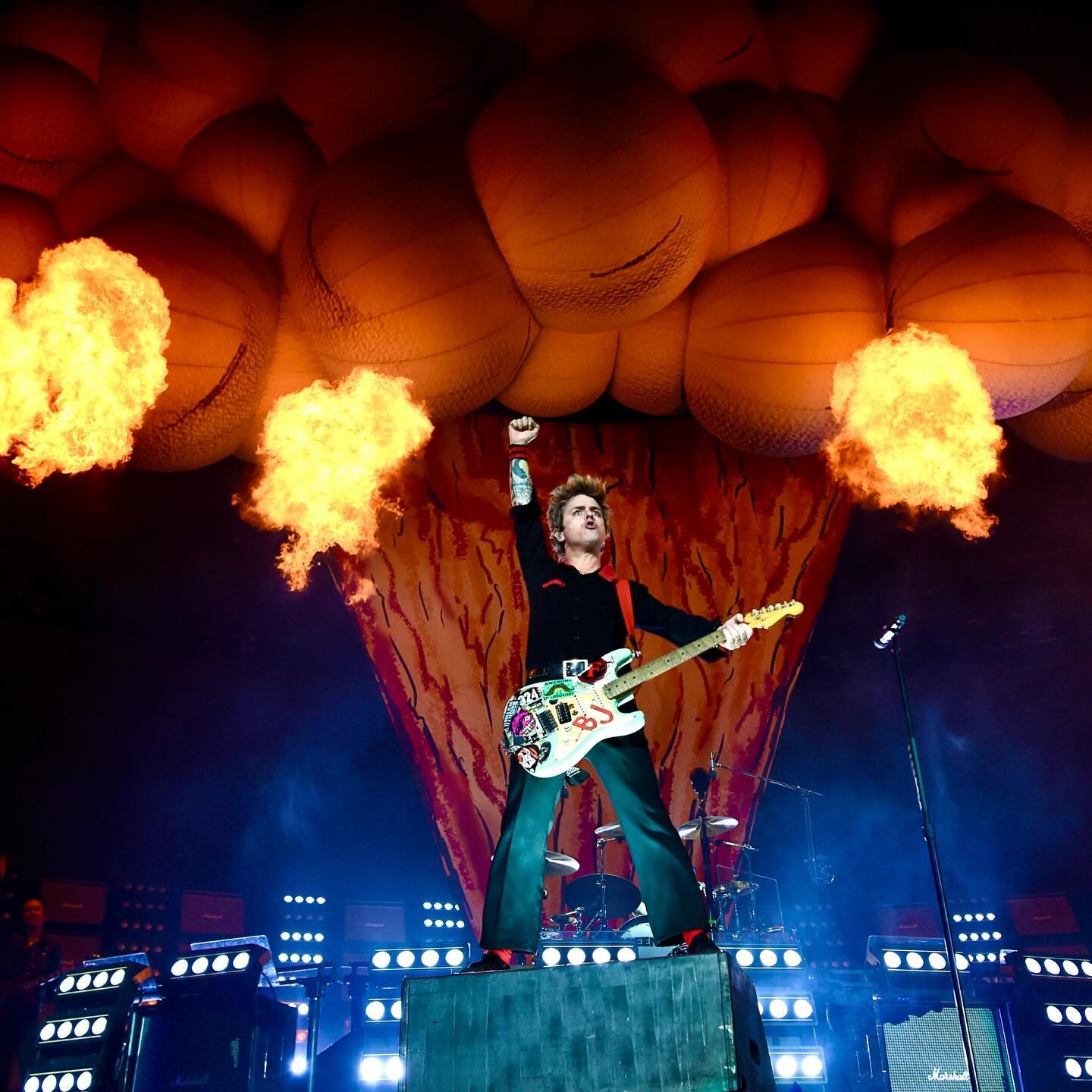 Billy Joe raises his fist in front of big flames
