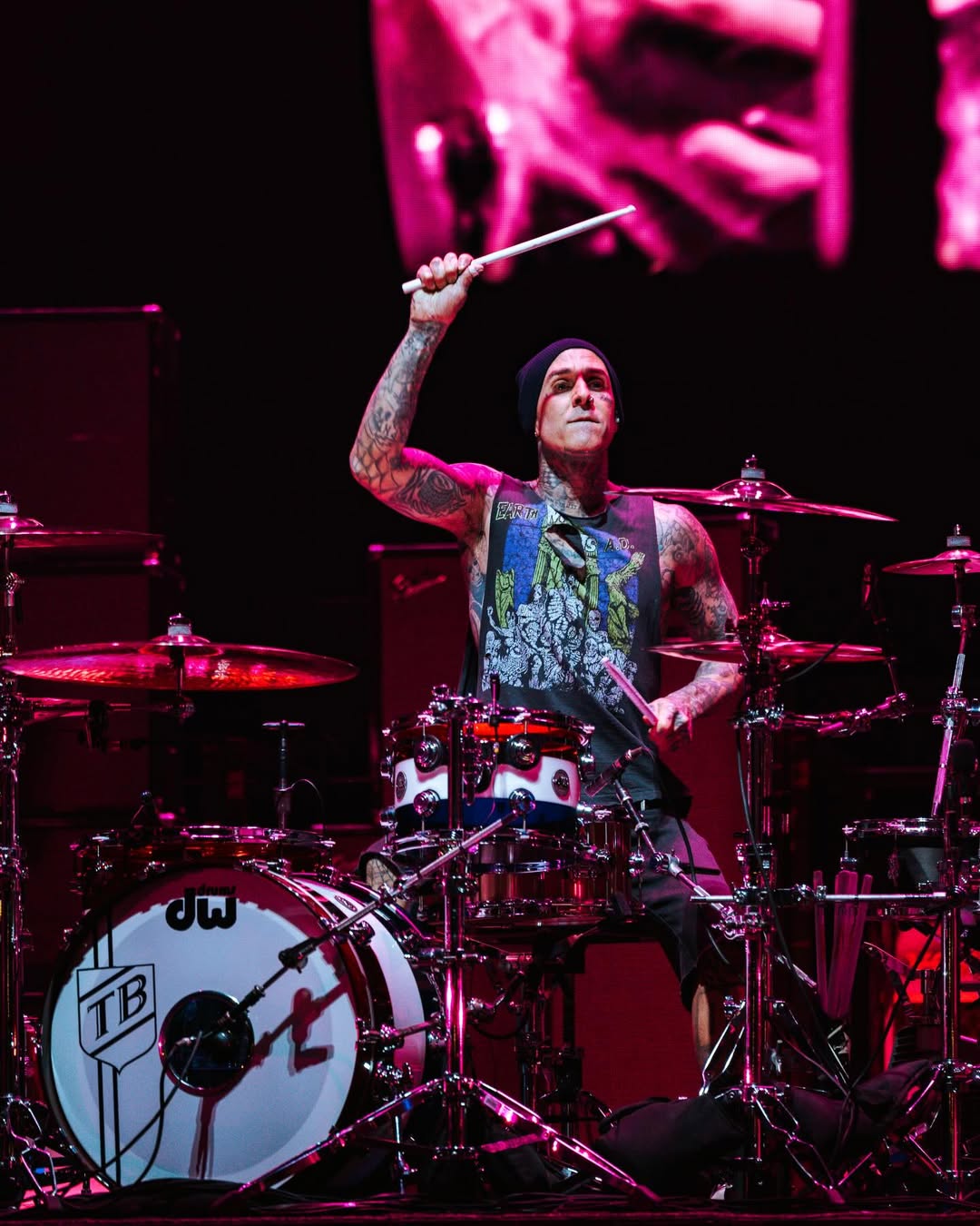 Travis raising his drumstick in the air