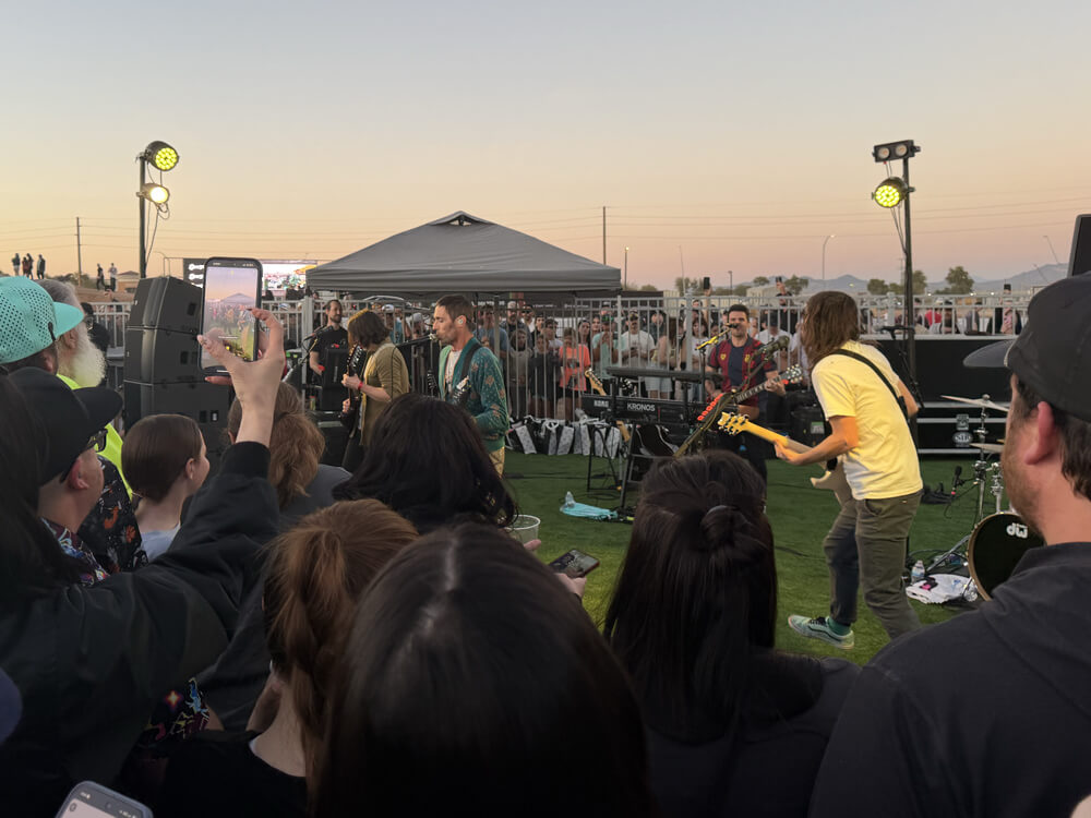 The All-American Rejects performing in the grass, surrounded by fans