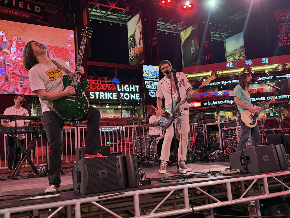 The All-American Rejects performing, Nick has his foot up on the amp playing a green guitar