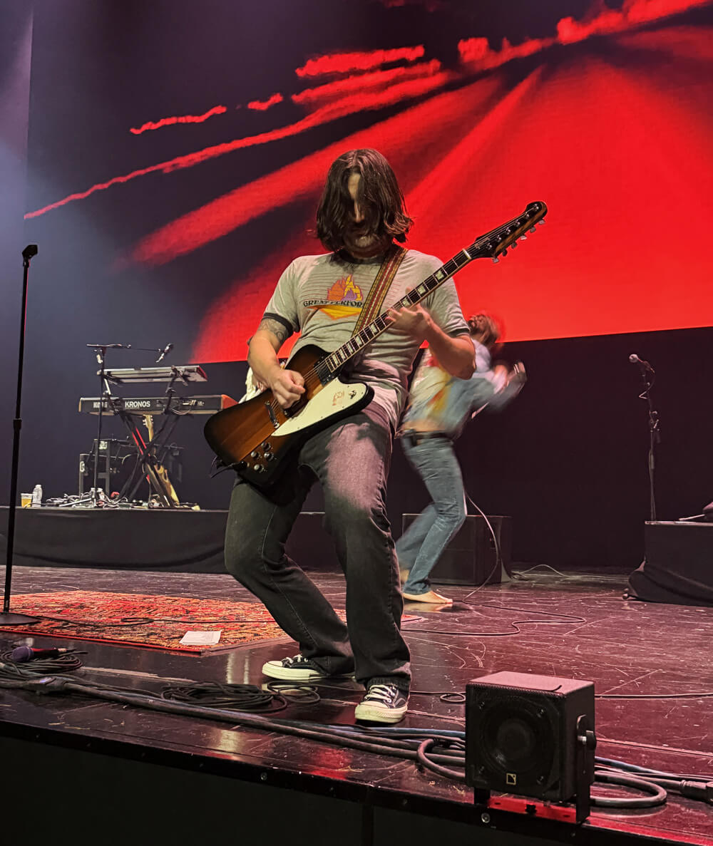 Nick playing guitar at the edge of the stage
